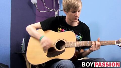 Young man plays guitar before dick stroking and cumming