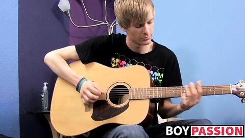 Young man plays guitar before dick stroking and cumming