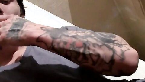 Tattooed Kyd Cash chainsmoking while working his cock in his boxer shorts