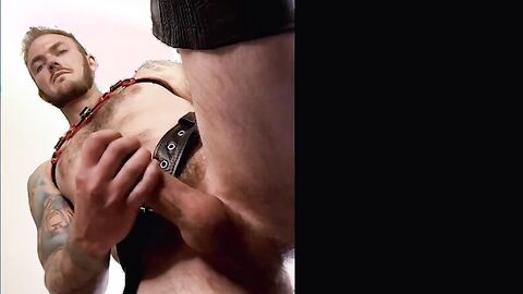 Hairy Christian Wilde in leather clothing wanks his hard cock until cumshot