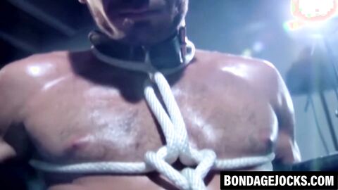 Tattooed wrestler bound and dominated by a fierce opponent