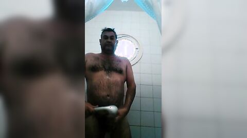 Osito caliente con una gran polla se ducha y se pajea.