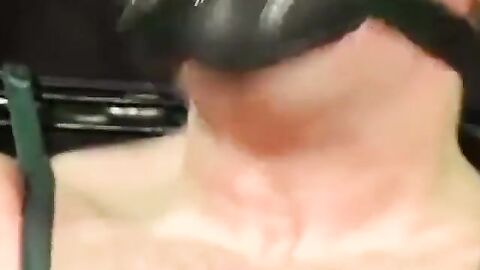 Bigg Pete roped down in chains with his mouth strapped shut