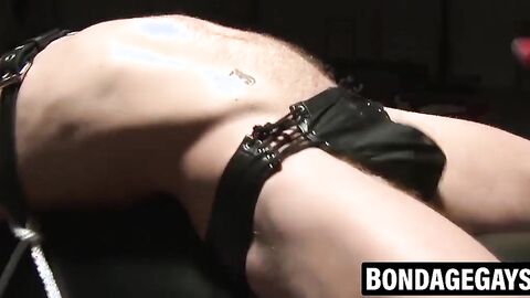 Tattooed hunk ball gagged and whipped in leather restraints
