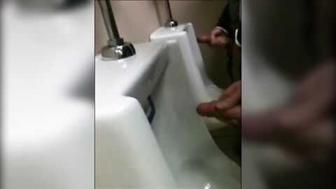 two slim dicks getting wanked at the urinals