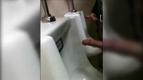 two slim dicks getting wanked at the urinals