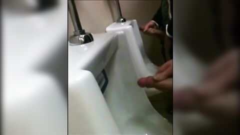 two slim dicks getting wanked at the urinals