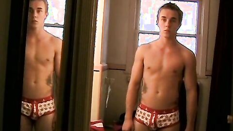 Twink Kelly Cooper shows off in front of a mirror in his undies