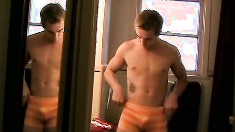 Twink Kelly Cooper shows off in front of a mirror in his undies