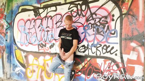 Young guy masturbates in public in front of graffiti wall