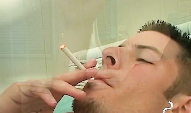 Mike Roberts blows a cloud of smoke while rubbing his cock