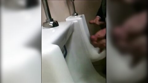 two slim dicks getting wanked at the urinals