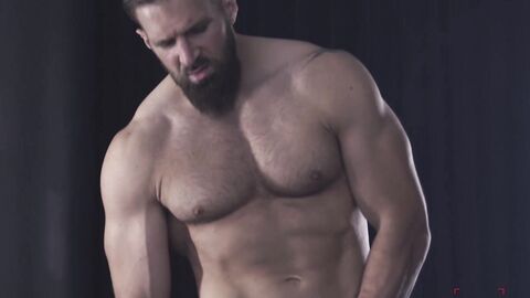 Hairy hunk Chuck Conrad works his massive dick with his two hands after flexing his t