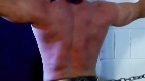 Muscled Derek Pain takes flogging all over his sexy back til it is rosy red