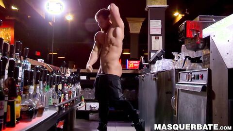 Buff stud strips nude to masturbate passionately behind bar